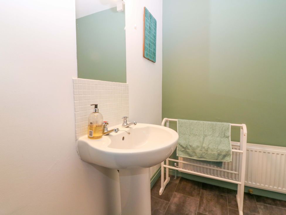 A bathroom with a sink and towel rack at Bridle Cottage in Cove