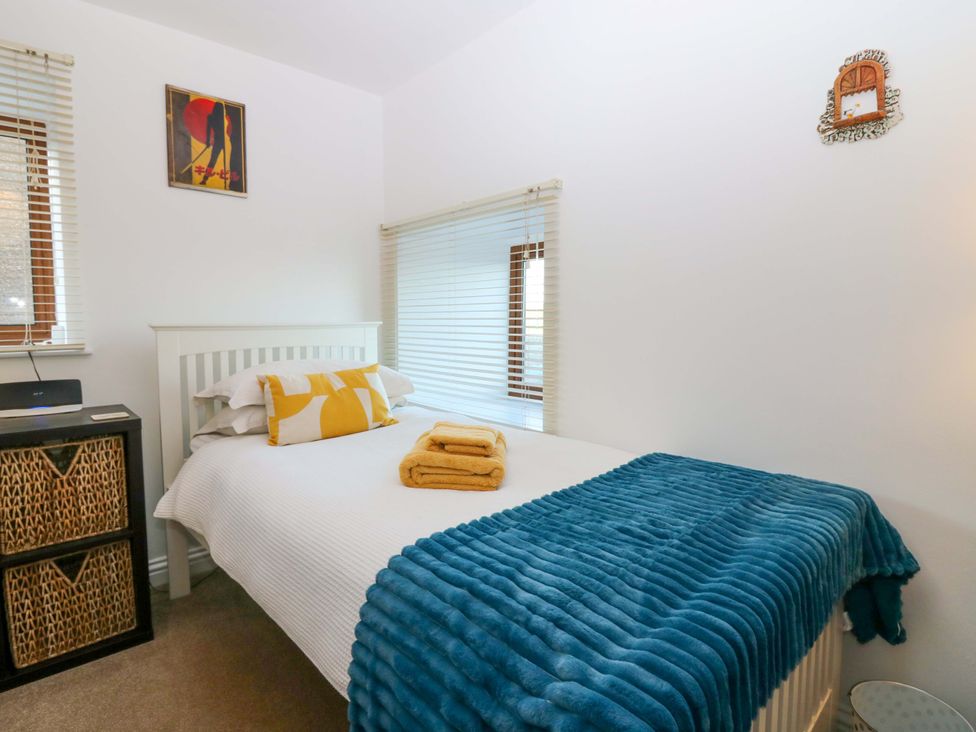 A bedroom with a bed and nightstand at Bridle Cottage in Cove