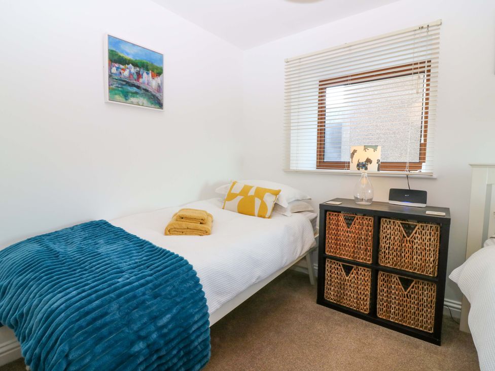 A bedroom with a bed and storage unit at Bridle Cottage in Cove
