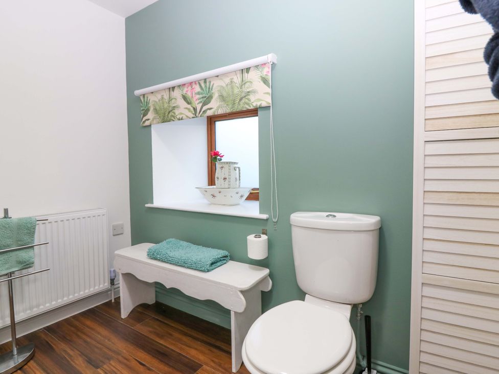 A bathroom with a toilet and a window at Bridle Cottage in Cove