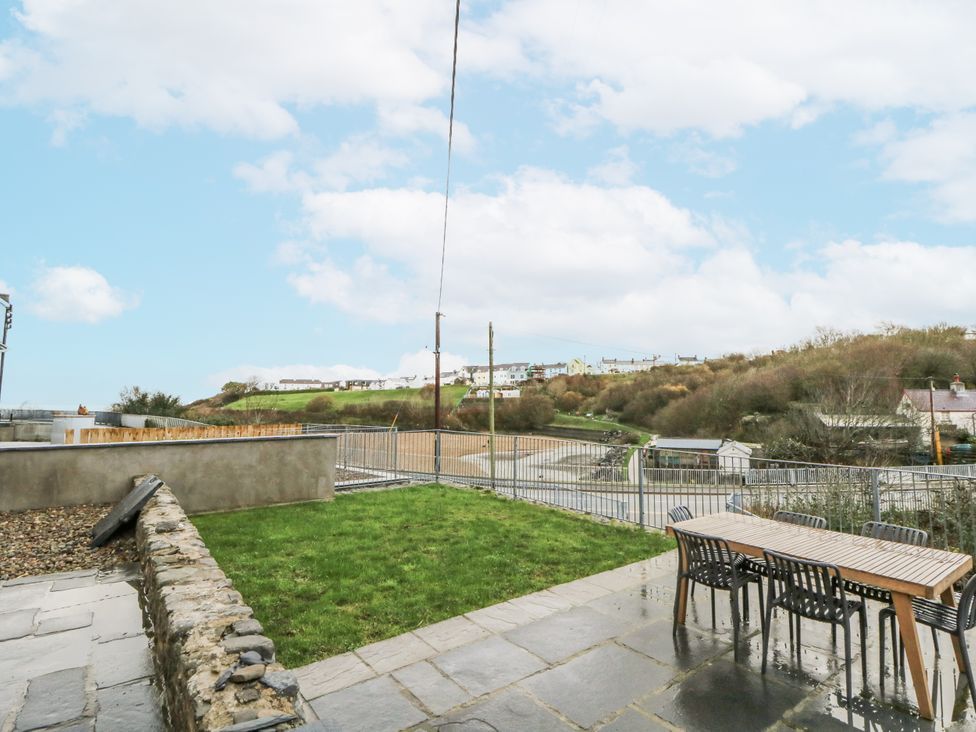 A garden with a table and chairs at Fronglyd in Aberporth