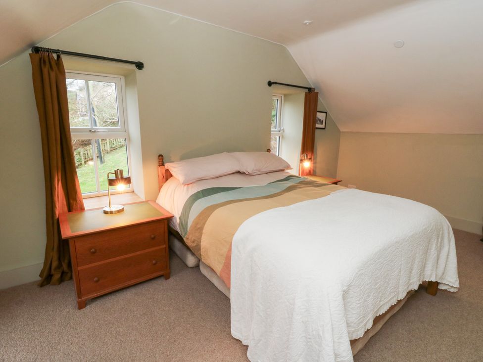 A bedroom with a bed and nightstand at Fronglyd in Aberporth