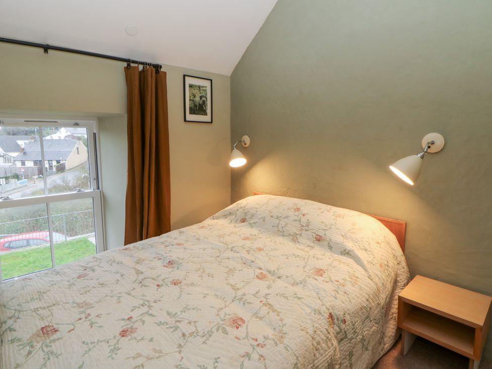 A bedroom with a bed and nightstand at Fronglyd, Aberporth