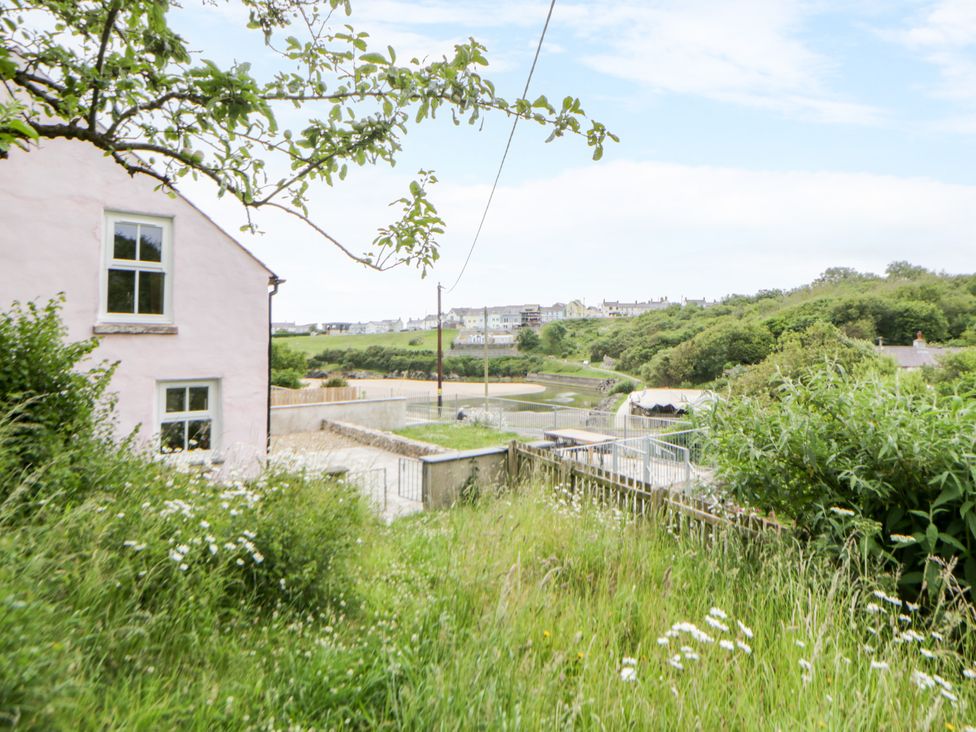 A house with grass and a path near water at Fronglyd Aberporth