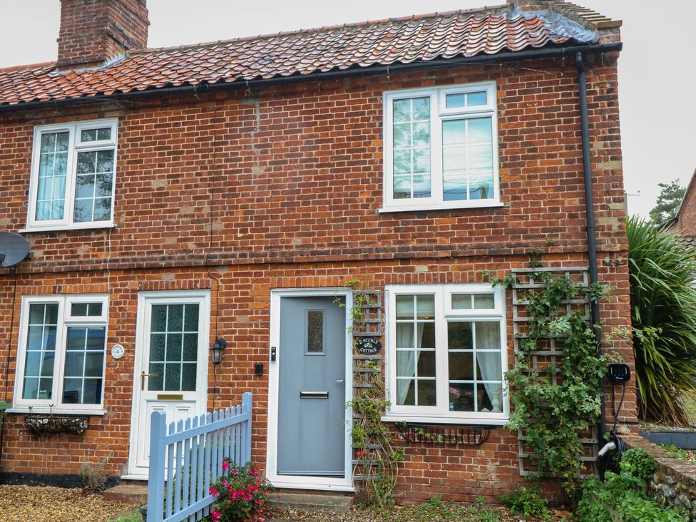A brick exterior of a house with windows and a front door at Beeble Cottage in Fakenham