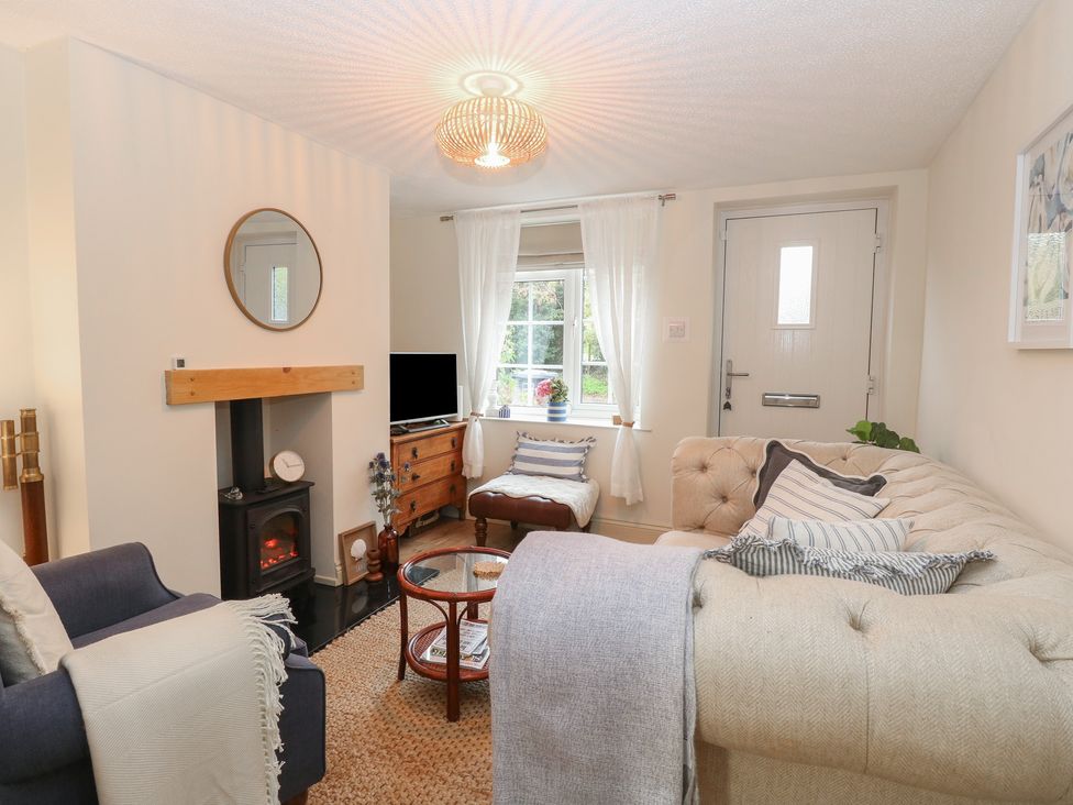 A living room with a sofa and a television at Beeble Cottage in Fakenham
