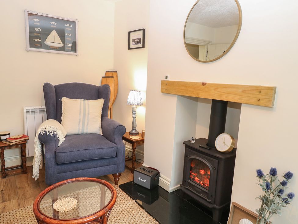 A living room with an armchair and fireplace at Beeble Cottage in Fakenham