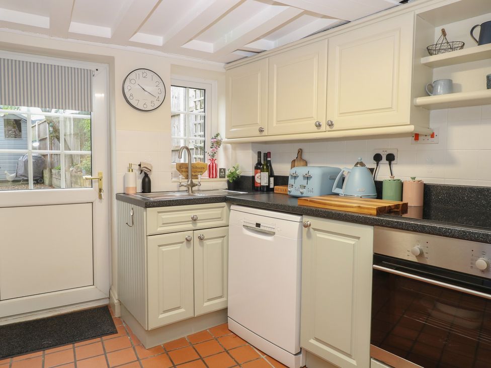 A kitchen with appliances and a door at Beeble Cottage in Fakenham