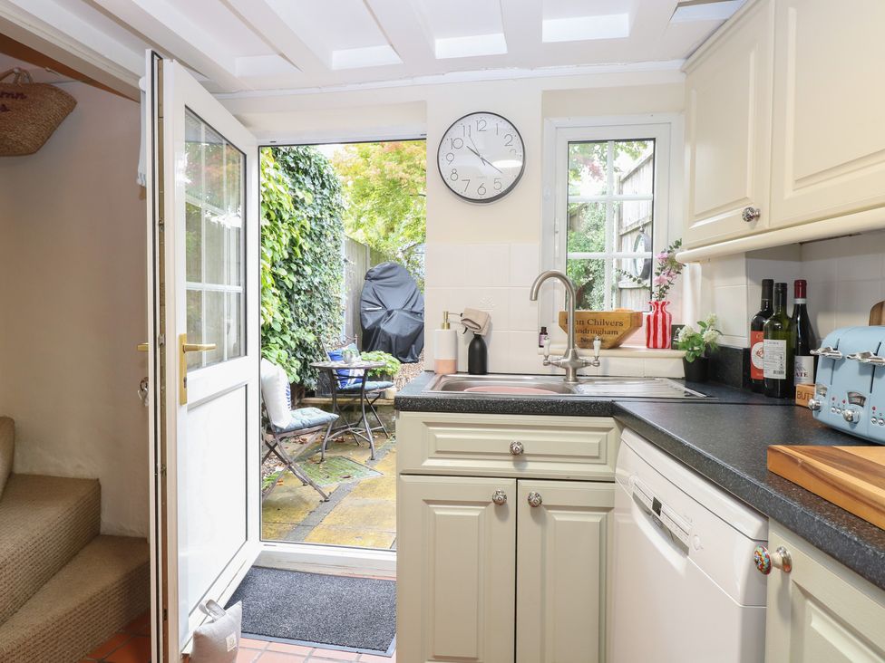 A kitchen with a door leading to the garden at Beeble Cottage in Fakenham