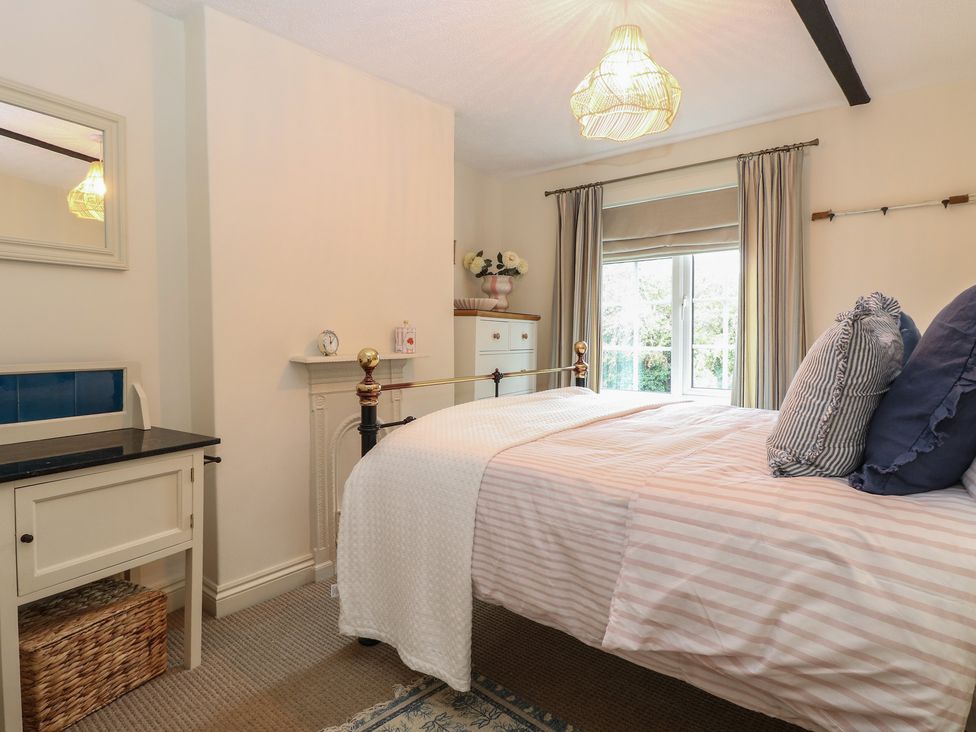 A bedroom with a bed and wardrobe at Beeble Cottage in Fakenham