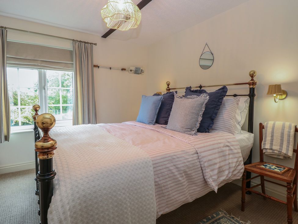 A bedroom with a bed and pillows at Beeble Cottage in Fakenham