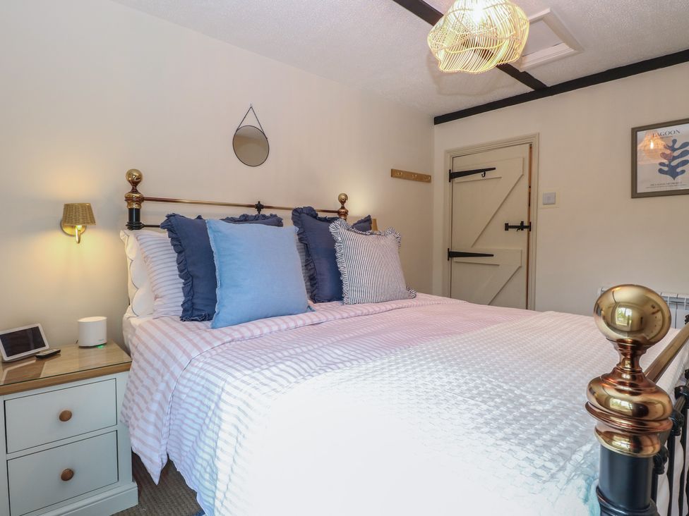 A bedroom with a bed and nightstand at Beeble Cottage in Fakenham