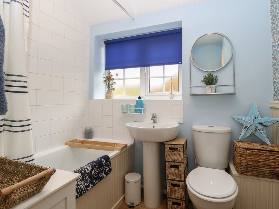 A bathroom featuring a bathtub, toilet, and sink at Beeble Cottage in Fakenham