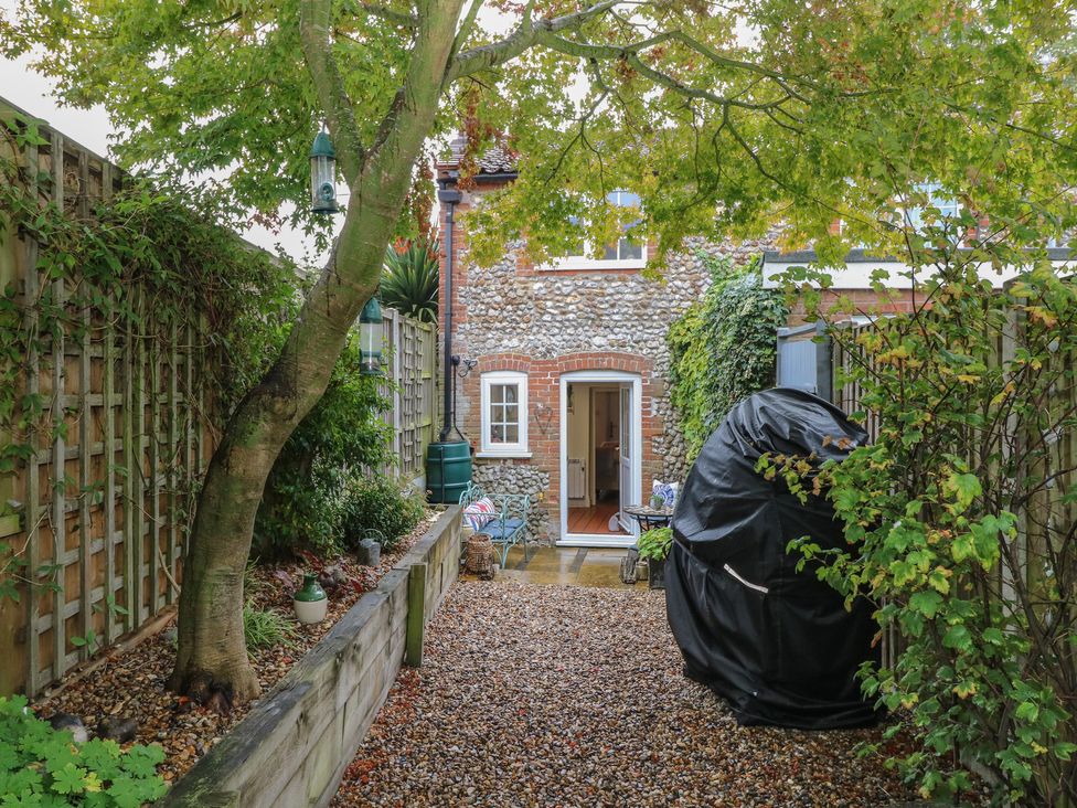 A garden with a gravel path and a door at Beeble Cottage in Fakenham