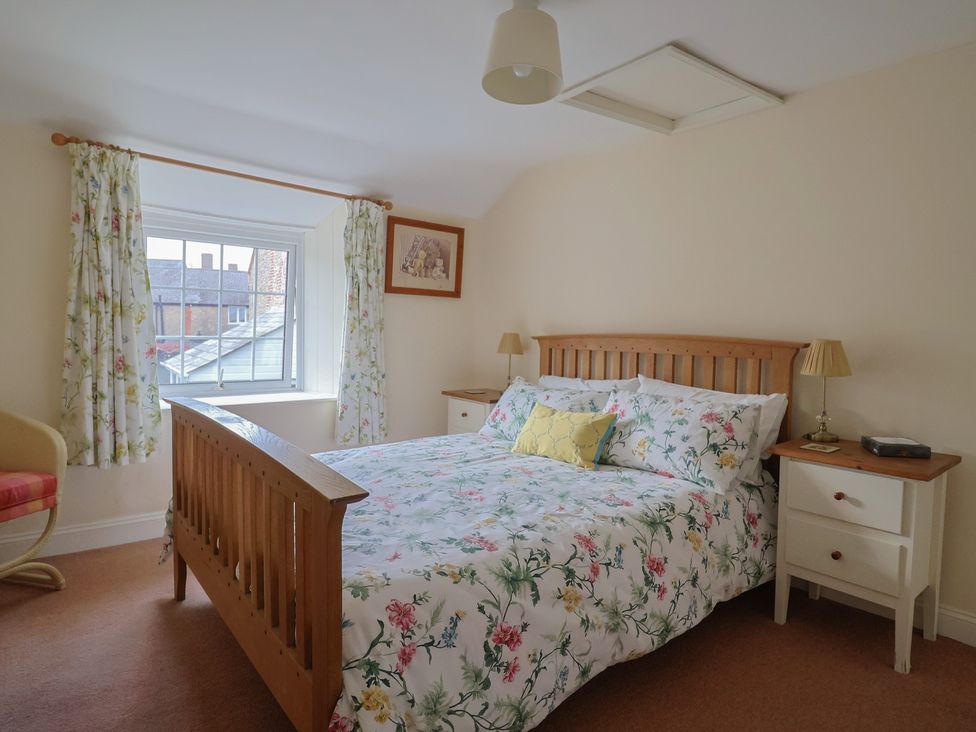 A bedroom with a bed and bedside tables at Vine Cottage in Burton Bradstock
