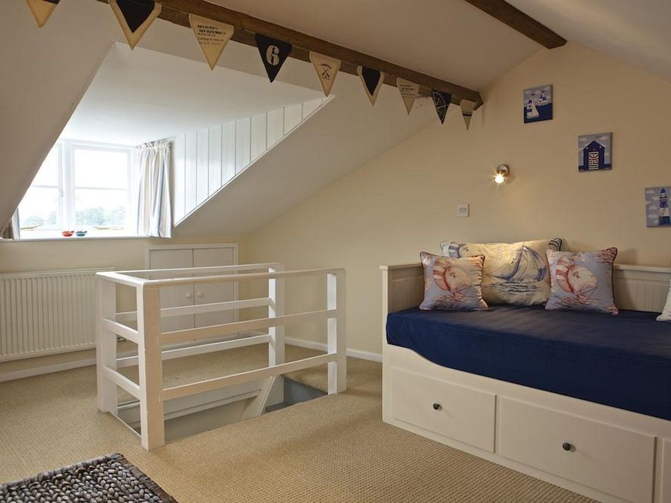 A bedroom with a bed and decorative pillows at St Leonards in Salcombe