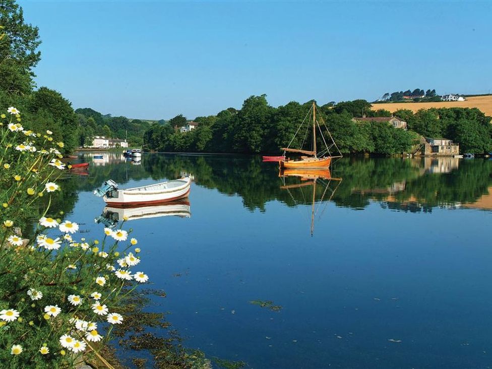 A scenic view of a river with boats and greenery at St Leonards, Salcombe