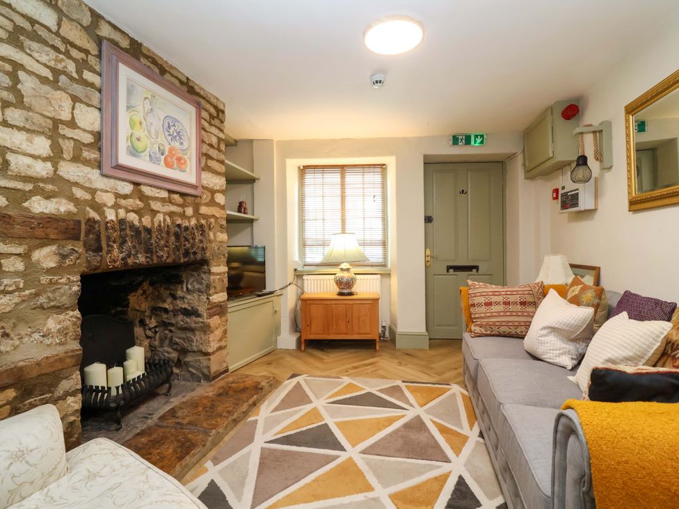 A living room with a fireplace and sofa at 29 Spring Street in Chipping Norton