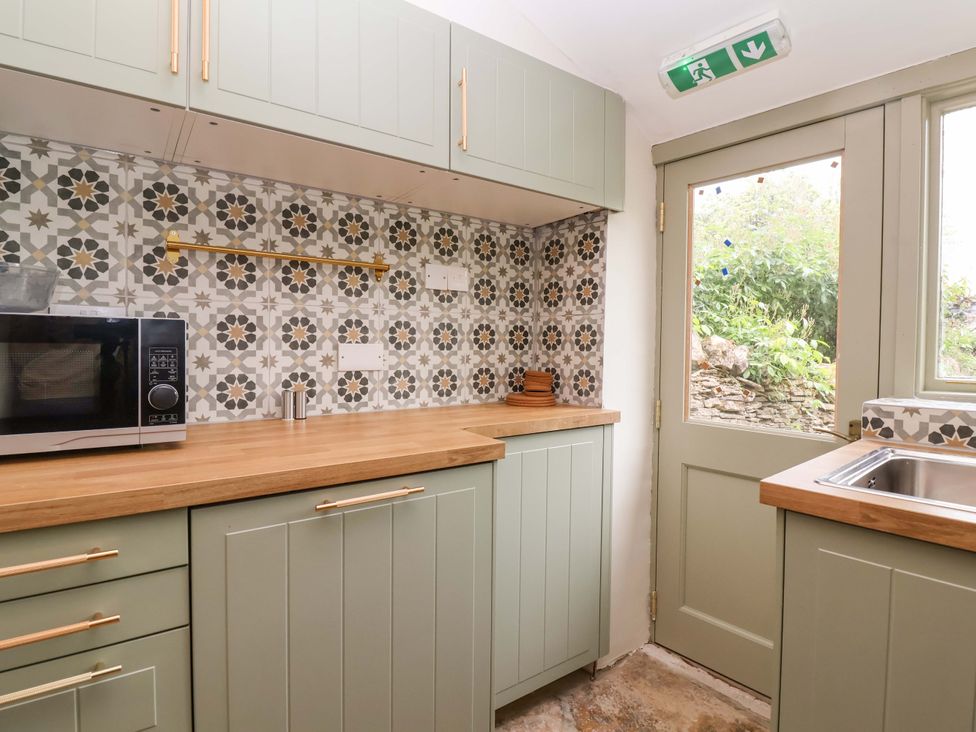 A kitchen with cabinets and a microwave at 29 Spring Street Chipping Norton
