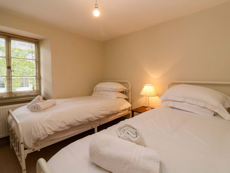 A bedroom with two beds and a lamp at 29 Spring Street Chipping Norton