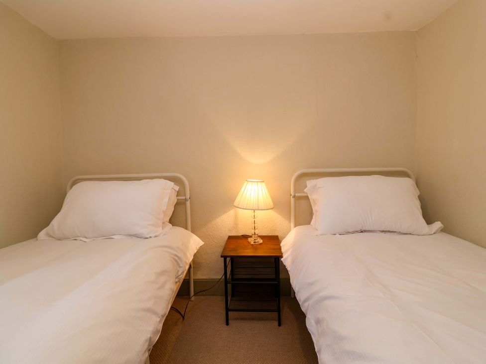 A bedroom with two beds and a lamp on a nightstand at 29 Spring Street Chipping Norton
