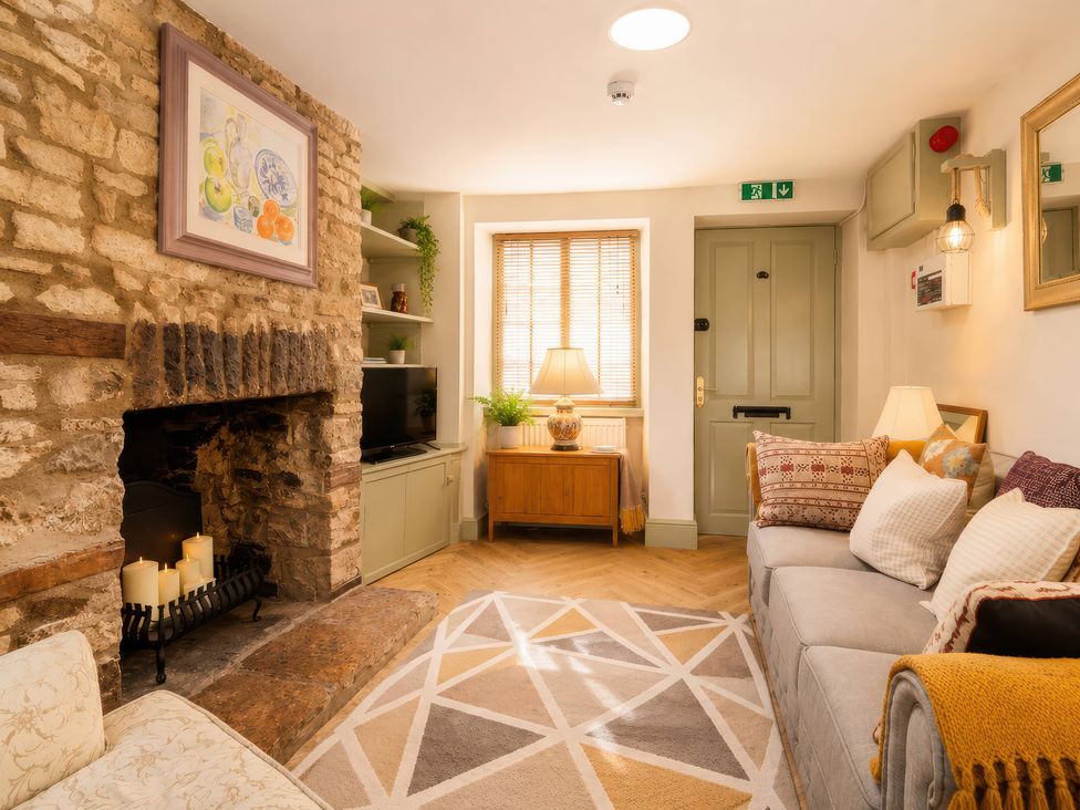 A living room with a fireplace and sofa at 29 Spring Street Chipping Norton