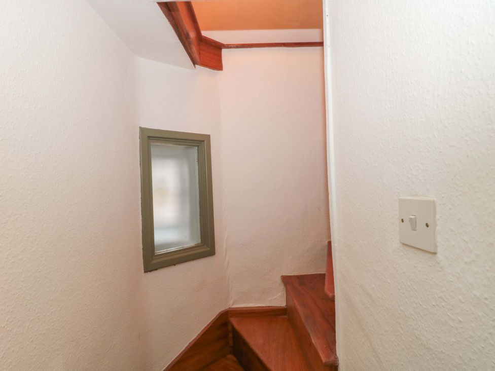 A staircase leading up with a window and light switch at 6 Priory Lane Burford