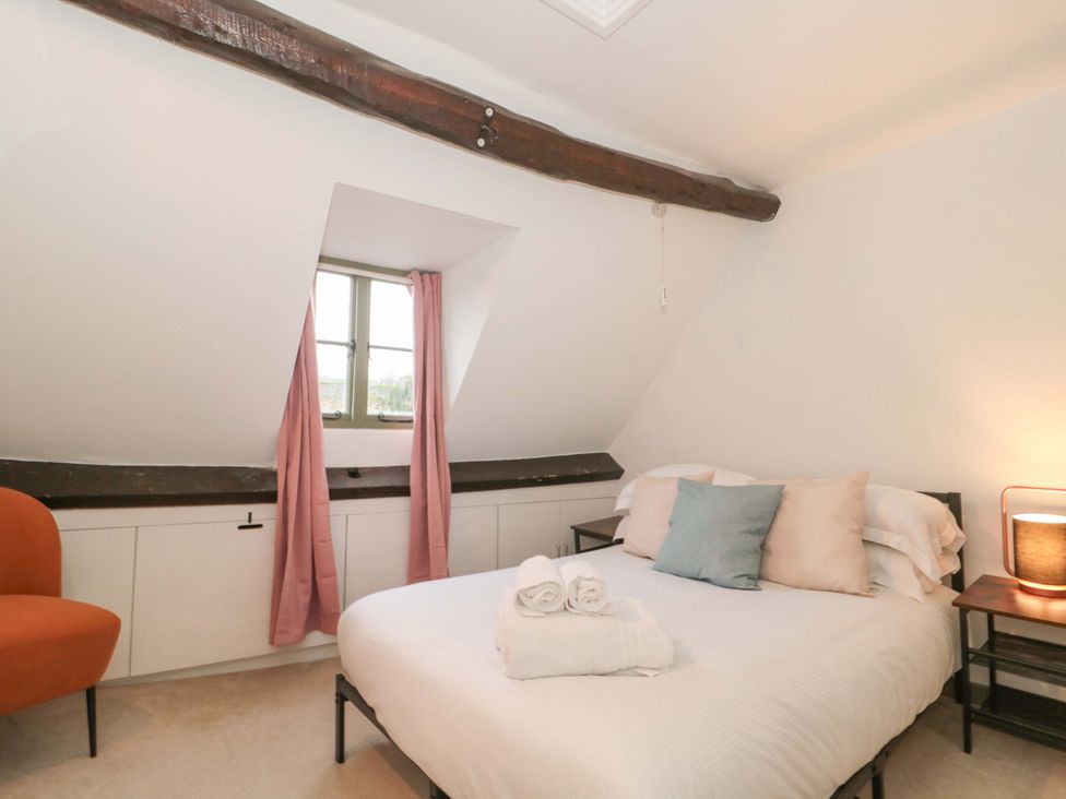 A bedroom with a bed and armchair at 6 Priory Lane Burford
