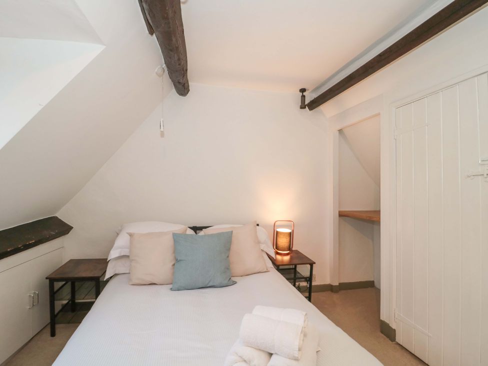 A bedroom with a bed and bedside table at 6 Priory Lane in Burford