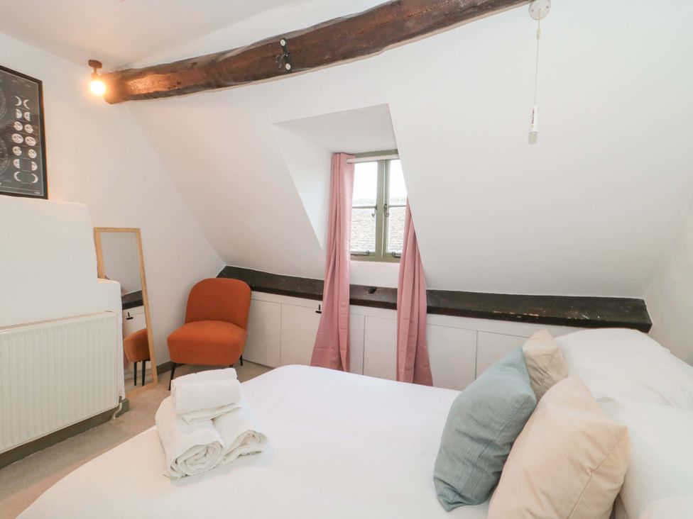 A bedroom with a bed and chair at 6 Priory Lane Burford