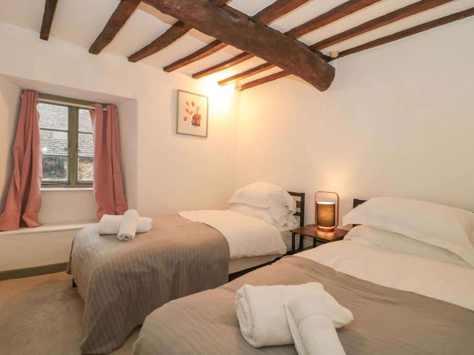 A bedroom with two beds and a window at 6 Priory Lane Burford