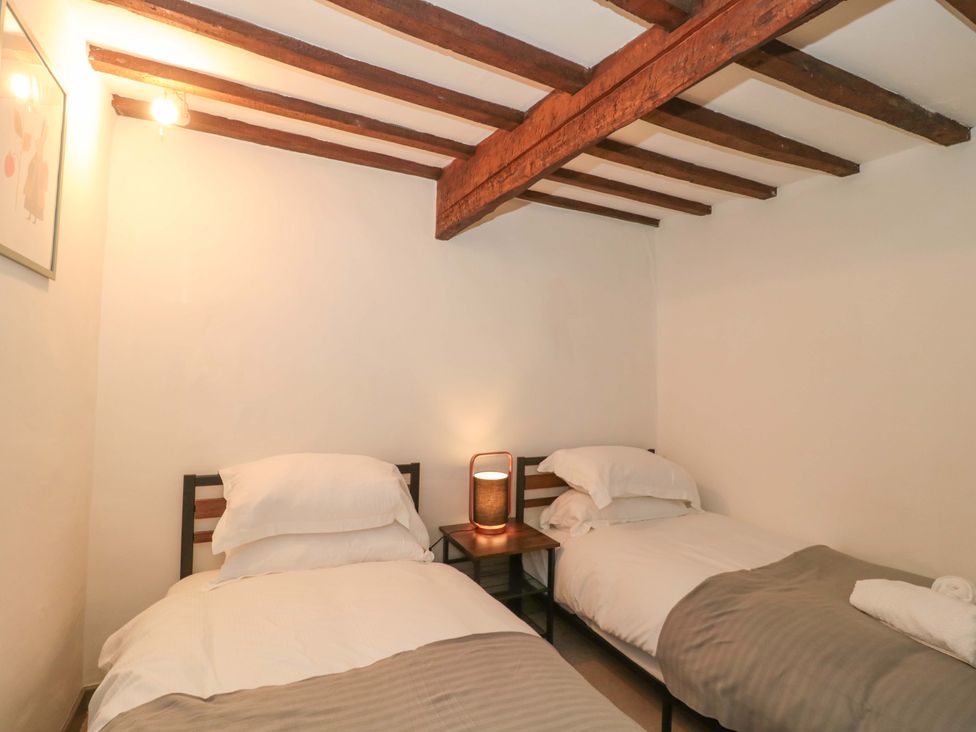 A bedroom with two beds and a nightstand at 6 Priory Lane Burford