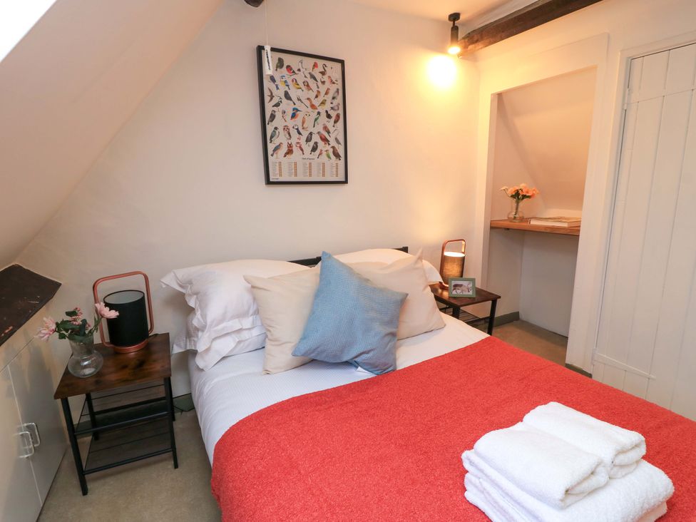 A bedroom with a bed and a nightstand at 6 Priory Lane Burford