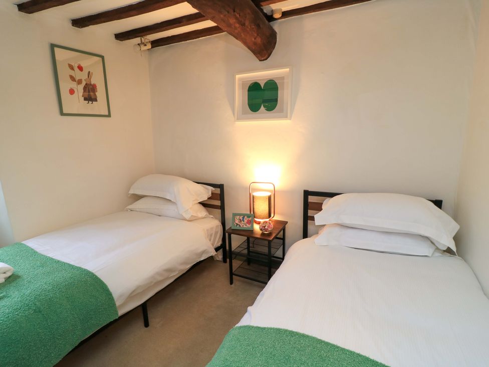 A bedroom with twin beds and a nightstand at 6 Priory Lane Burford