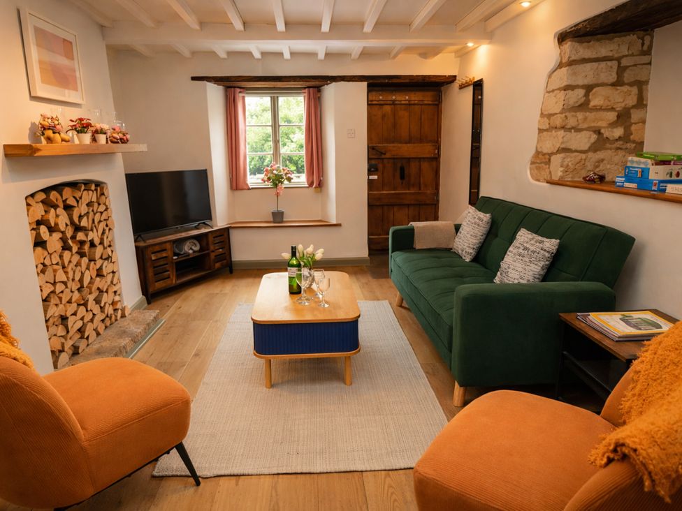 A living room with a sofa and television at Burford Apple in Burford