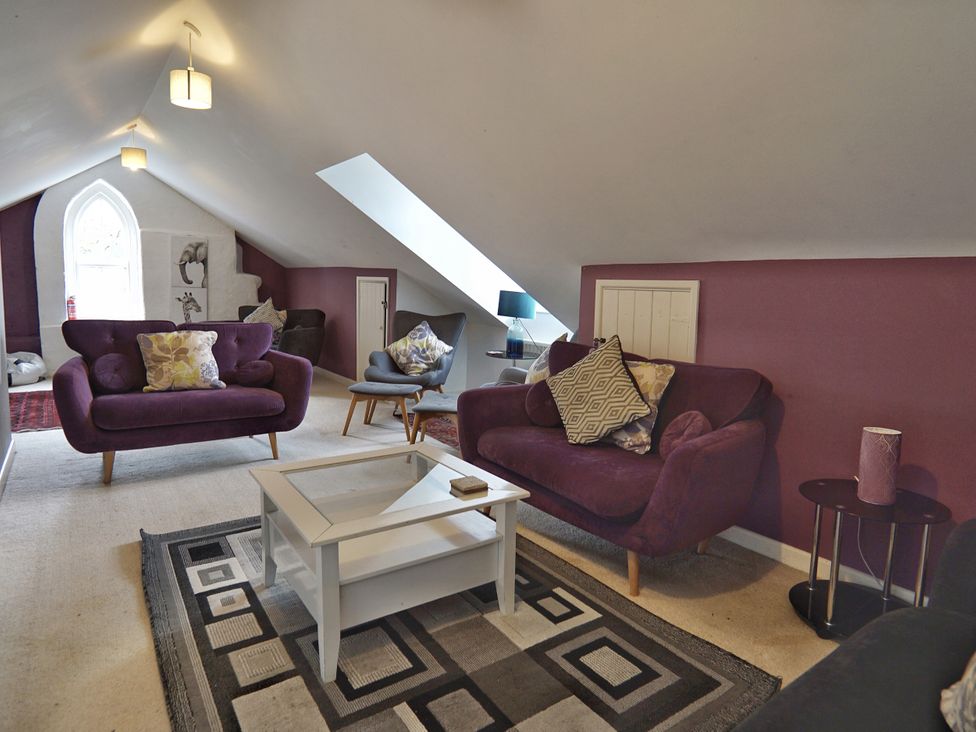 A living room with purple sofas and a coffee table at Roselyn House in Par
