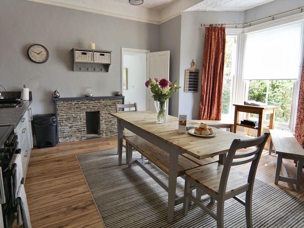 A kitchen with a wooden table and chairs at Roselyn House in Par