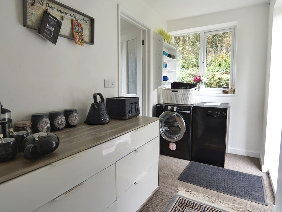 A laundry room with a washing machine and dryer at Roselyn House in Par
