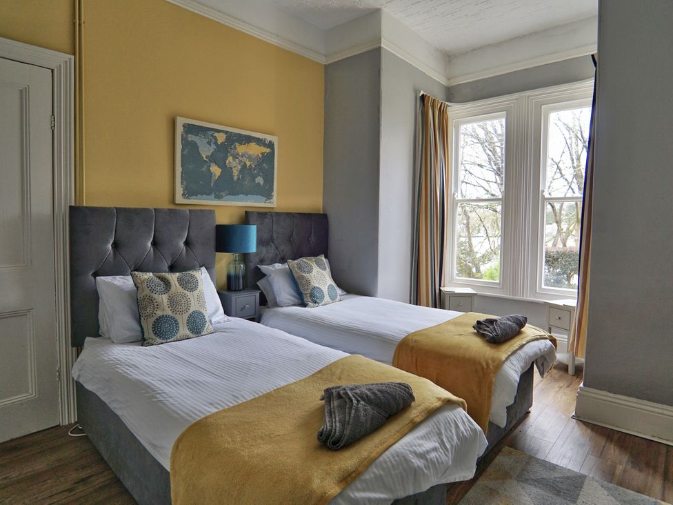 A bedroom with two beds and a world map at Roselyn House, Par