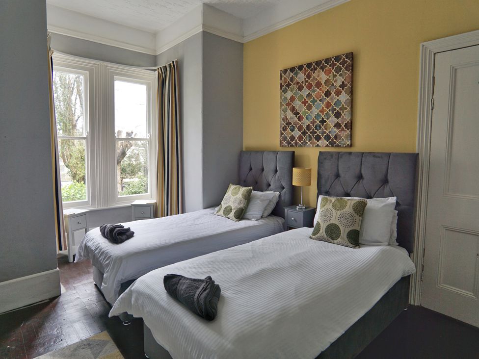 A bedroom with two beds and a lamp at Roselyn House in Par