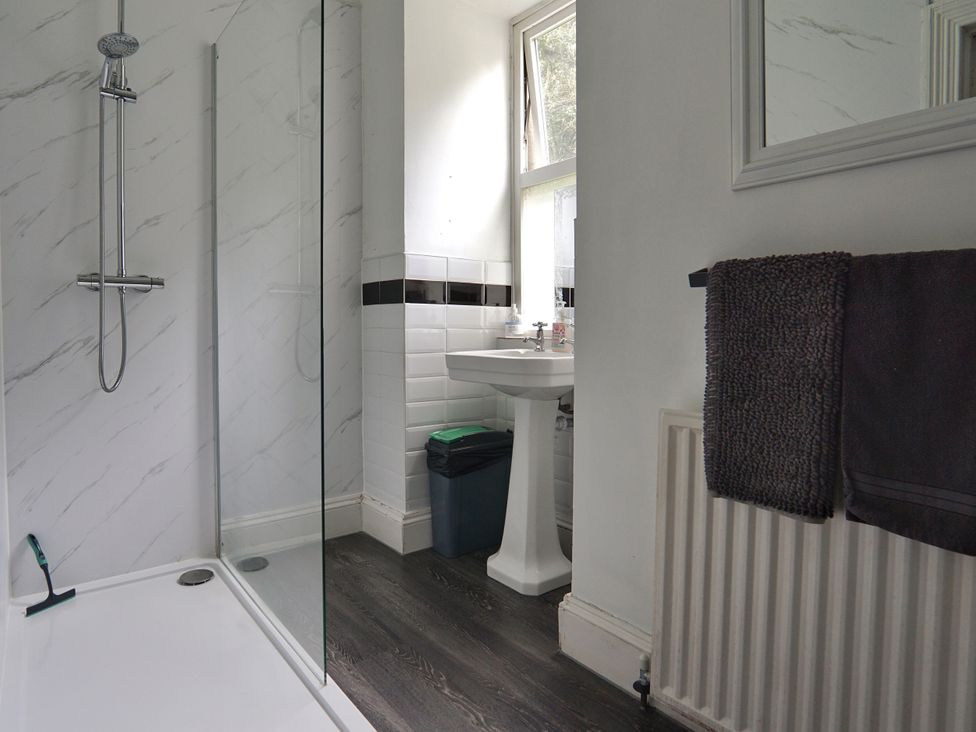 A bathroom with a shower, sink and towel at Roselyn House in Par