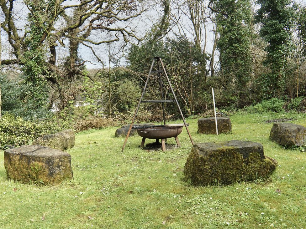 An outdoor space with a fire pit and stone seating at Roselyn House in Par