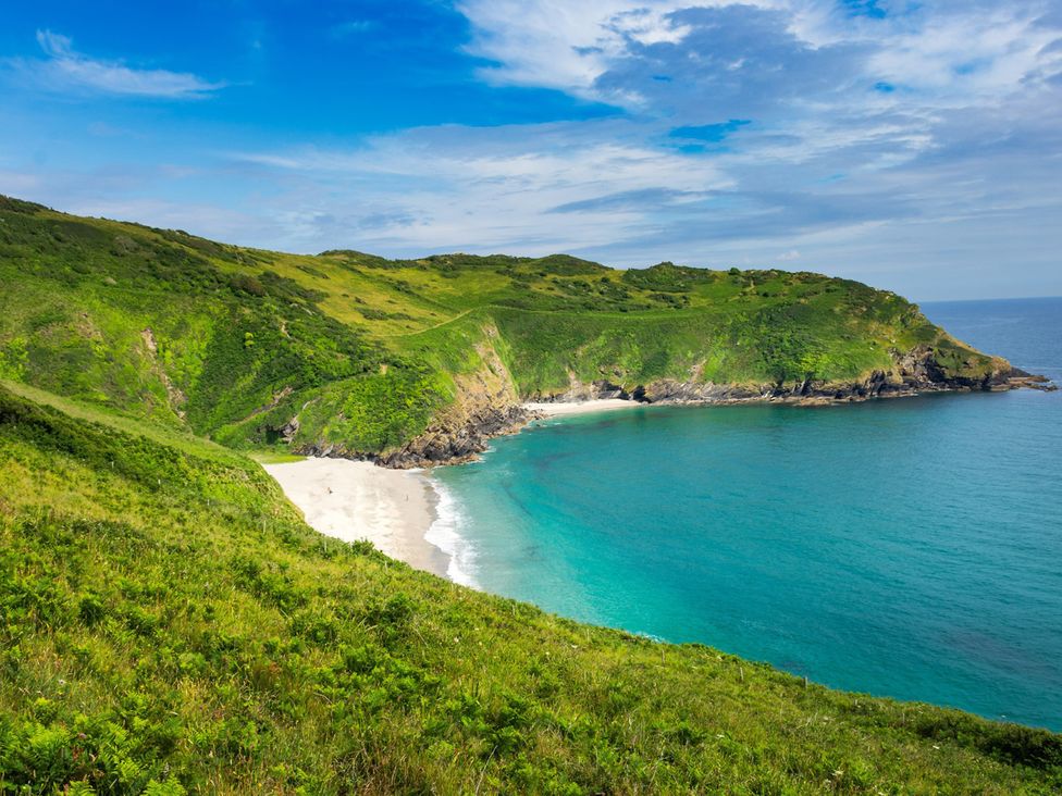 A beach with hills and ocean at Roselyn House in Par
