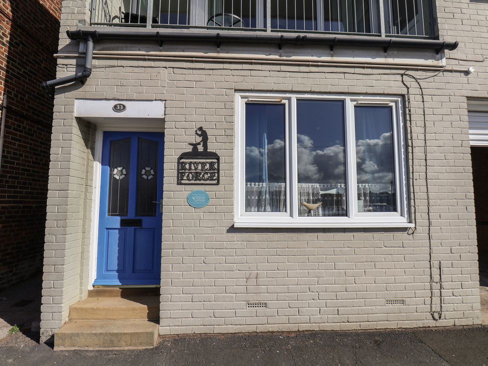 An exterior view with a blue door, window, and sign at Farriers Yard in Whitby