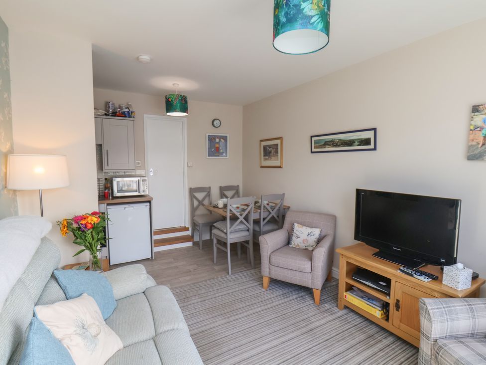 A living room with a sofa and dining area at Farriers Yard in Whitby