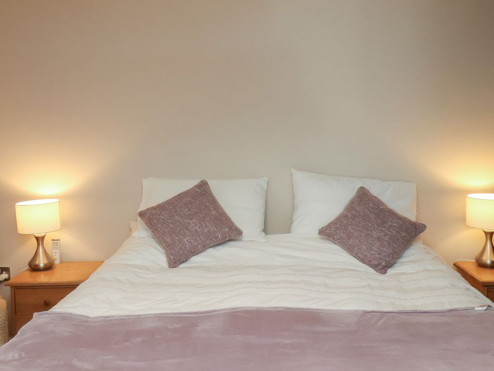 A bedroom with a bed and lamps at Farriers Yard in Whitby