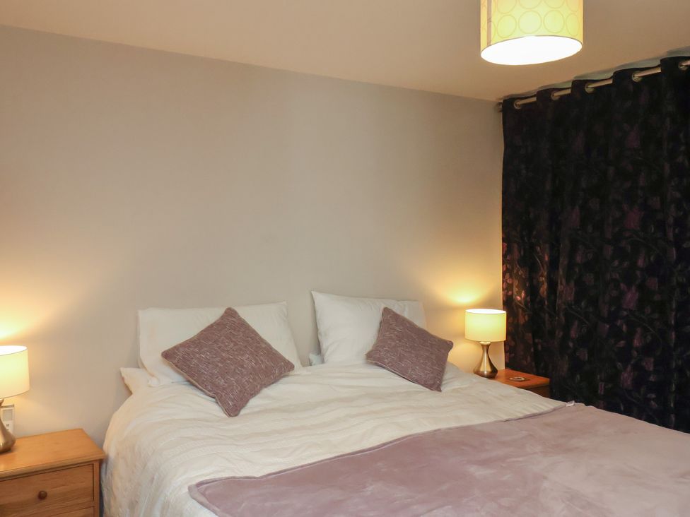 A bedroom with a bed and lamps at Farriers Yard in Whitby