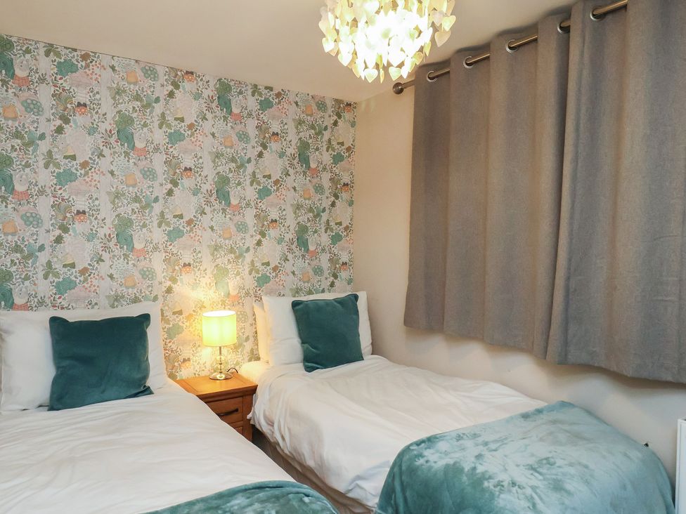 A bedroom with two beds and a lamp at Farriers Yard in Whitby