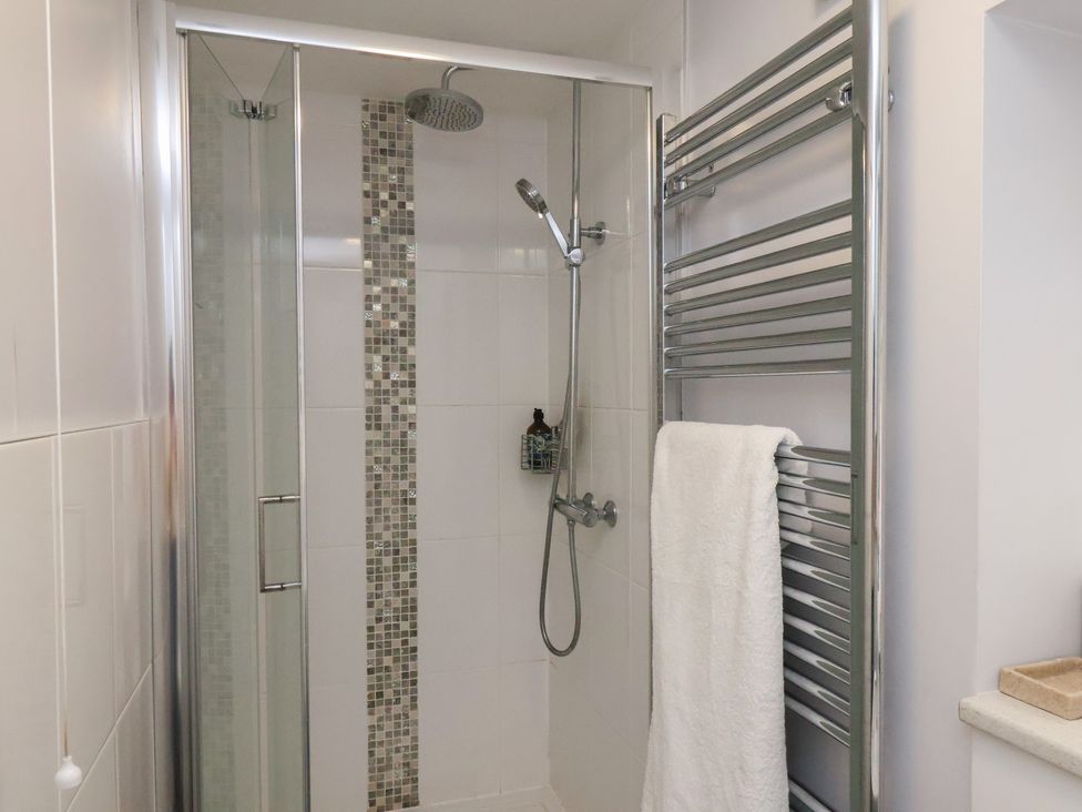 A bathroom with a shower and towel rail at Farriers Yard in Whitby