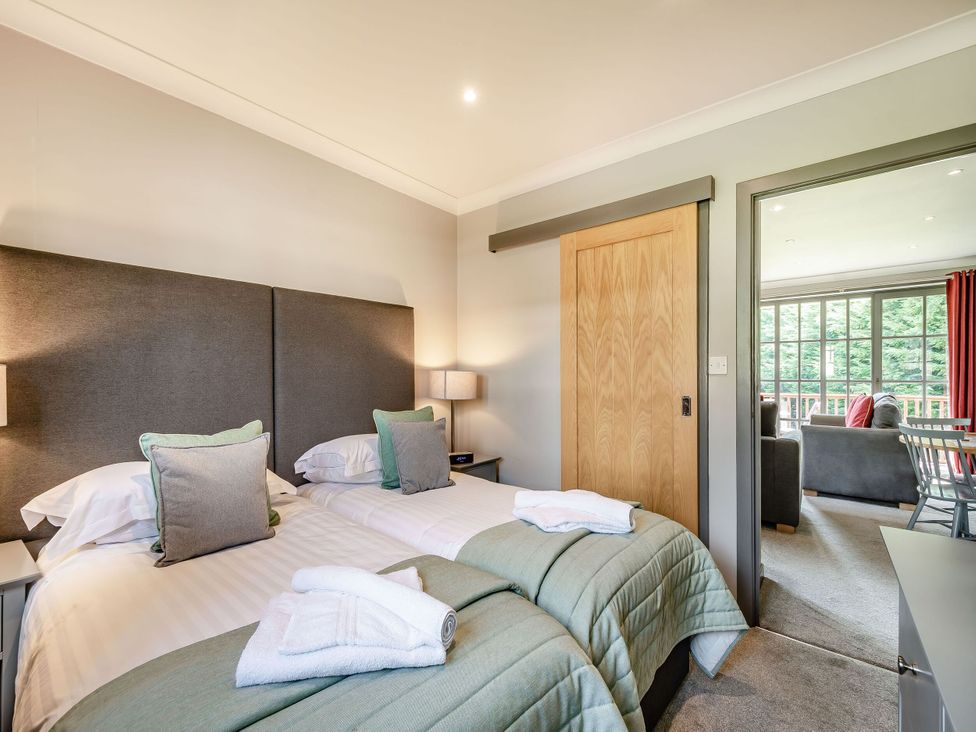 A bedroom with twin beds and an adjoining living area at Bargany in Girvan